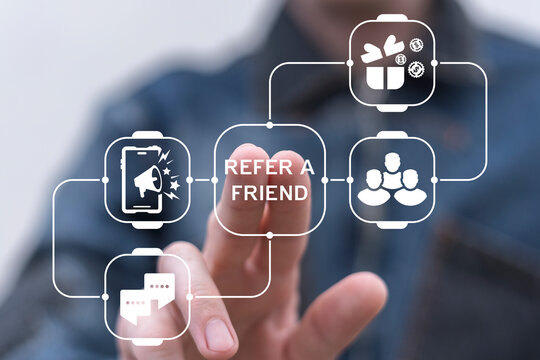 Man using virtual screen presses text: REFER A FRIEND. Referral marketing or affiliate marketing concept. Invite friends to refer a friend loyalty program to win online reward. Refer and earn.