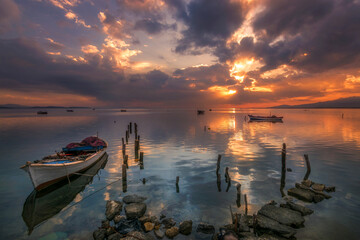 boats waiting in the reflective water clouds in the sky sunset colors