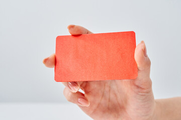 赤いカードを持つ女性の手元