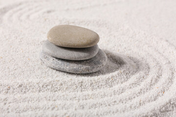 Stack of stones on sand with lines in Japanese rock garden.  Zen concept