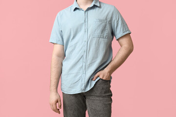 Young man in stylish blue collar shirt on pink background