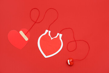 Composition with paper heart-shaped blood pack for transfusion, grip ball and paper heart on red...