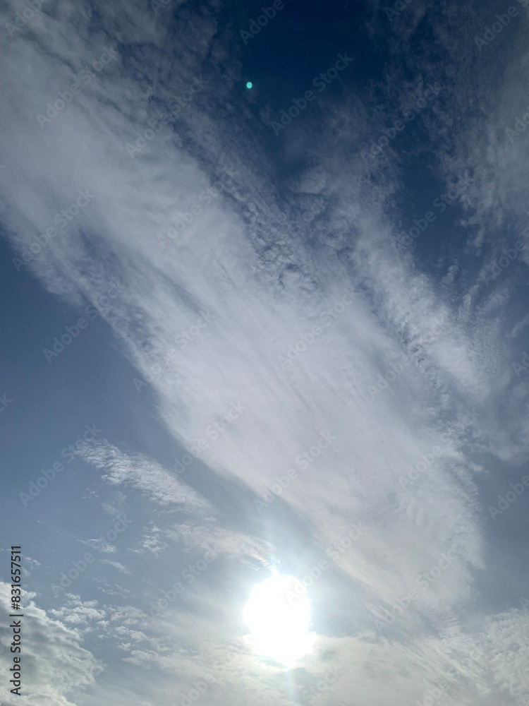 Wall mural blurred image of sky with clouds and sun.