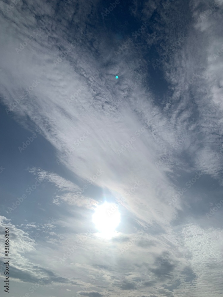 Wall mural blurred image of sky with clouds and sun.