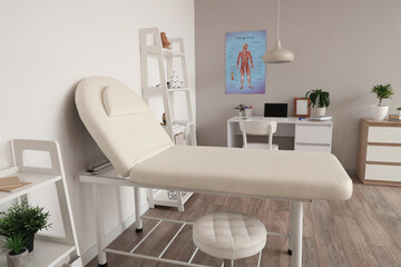 Interior of medical office with couch, shelf units and doctor's workplace