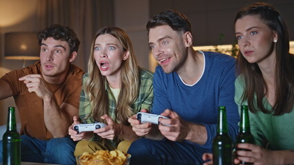 Emotional gamers watching video game at living room close up. Gambling friends