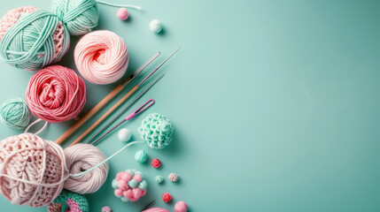 assorted knitting yarn and crochet tools on pastel teal background with copy space