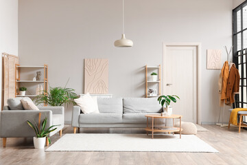 Interior of stylish modern living room with grey sofas and houseplants