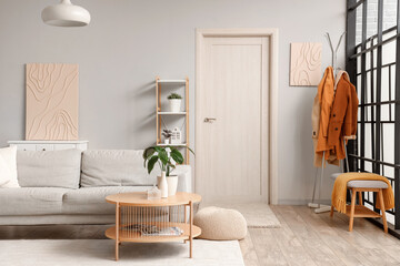 Interior of stylish modern living room with grey sofa and houseplants