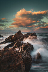 waves crashing on the rocks sea sky in midday and sunset light
