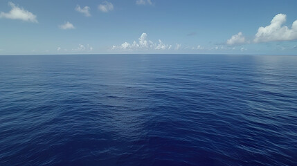 Fototapeta premium Aerial View of Calm Blue Ocean with Clear Sky and Scattered Clouds