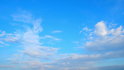 A clear blue sky with scattered fluffy white clouds, creating a serene and peaceful atmosphere. The...