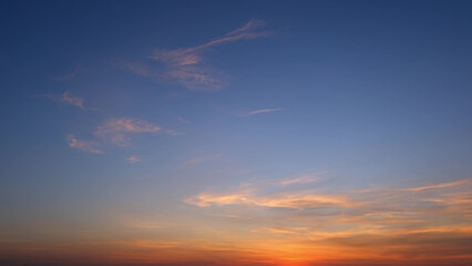 A tranquil sunrise with a gradient sky transitioning from deep blue at the top to warm orange and...