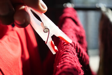 putting a blue clothespins on cloth 