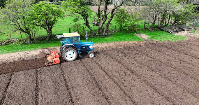Aerial view of a Ford 6610 tractor rotovating a ploughed field for crops at Magill&rsquo;s farm Larne County Antrim Northern Ireland on 16-05-24
