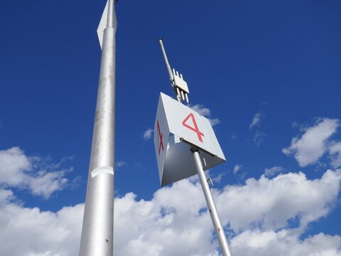 Communications antenna with number four with blue sky and clouds background - Powered by Adobe
