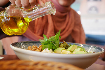 Healthy Salad Prep with Olive Oil in a Cozy Restaurant. Enjoy a fresh and wholesome meal