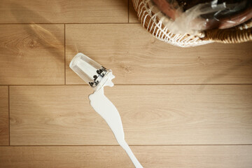 Spilled white milk on a wooden floor ,