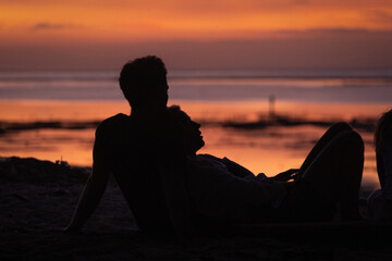 Couple watching the sunset on the beach.