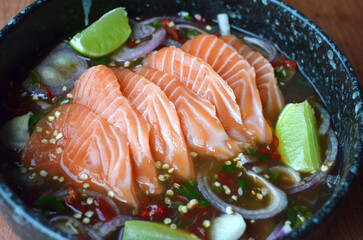 sliced salmon with parsley leaf in the white plate isolated on white background