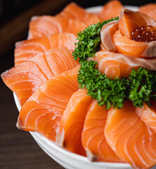sliced salmon with parsley leaf in the white plate isolated on white background