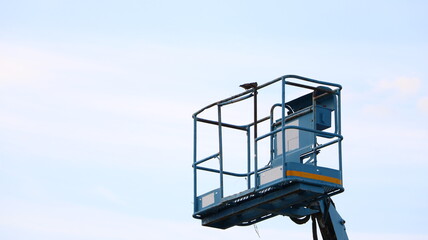 The aerial platform of the boom lift is carried to heights. with a bird perched on top