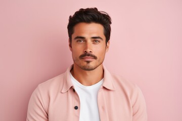 Fototapeta premium Portrait of handsome young man looking at camera while standing against pink background