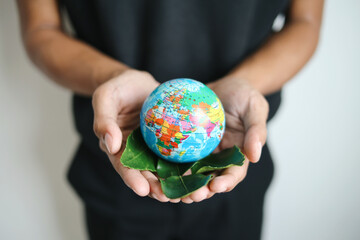 Hands Holding Globe And Leaf on Palms. Renewable and Sustainable Resources. Earth Day. 