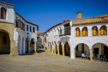 Fototapeta premium Stone arches with whitewashed walls in the main square of the Cáceres town of Garrovillas de Alconetar