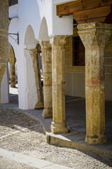 Stone arches with whitewashed walls in the main square of the Cáceres town of Garrovillas de...
