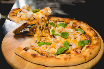 A chef preparing a cheese and basil pizza