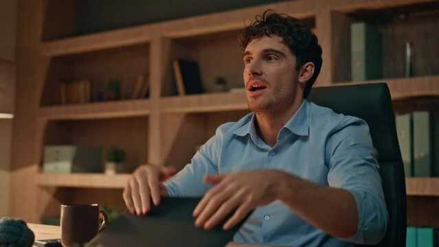 Online worker finish project in dark office close up. Freelancer closing laptop