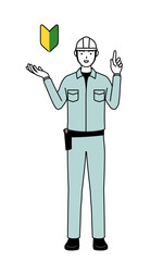 Man in helmet and workwear showing the symbol for young leaves.