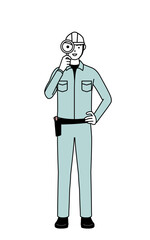 Man in helmet and workwear looking through magnifying glasses