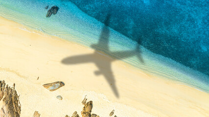 Aerial view of passenger plane silhouette and sandy beach blue sea with waves  Summer vacation sea travel concept