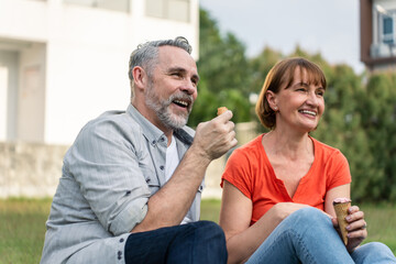 Caucasian senior man and woman having a picnic outdoors in the garden.