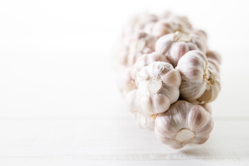 Ripe organic garlic clove and bulb on white wooden background.  Close-up. Selective focus.