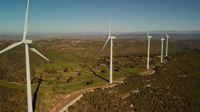 Windmills in Igualada, Barcelona on a sunny day with green hills and clear skies, aerial view