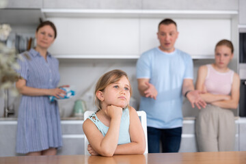 Parents and elder sister scold daughter in home kitchen