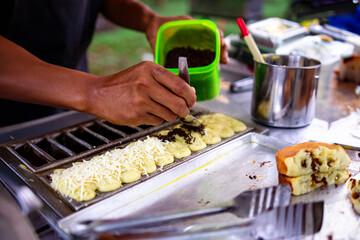 Street vendors make pukis cakes with various kinds of toppings