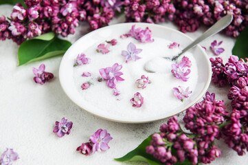 Bowl of Sugar With Lilac Blossoms on a Textured Background