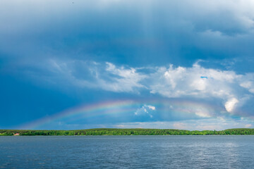 Rainbow over Blue lake with cloudy sky