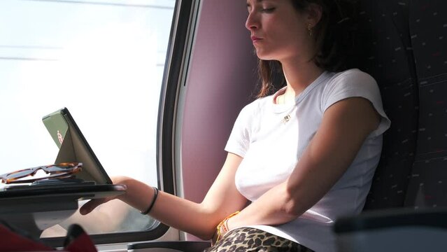 Young woman reading an ebook while traveling by train