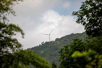 Wind Turbine on a hill under cloudy sky, showcasing sustainable energy generation