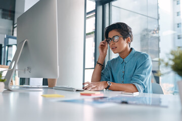 Businesswoman, checking or reading on computer in office, report for career with website development. Female person, desktop or confused expression with glasses, creative designer with digital glitch