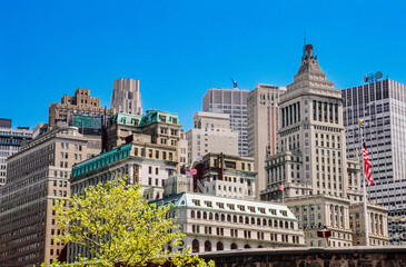 eingescanntes Diapositiv einer historischen Farbaufnahme dicht gedrängter, moderner und alter Bürogebäude im Finanzdistrikt von Lower Manhattan, New York bei schönem Wetter und blauem Himmel