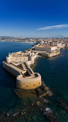 Siracusa Vista dal Mare. Sullo sfondo, l'Etna, sulla sinistra, nel Porto Grande, delle barche a vela. 