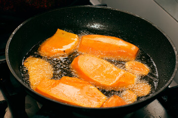 Closeup Sweet potato in boiling oil on cast iron frying pan