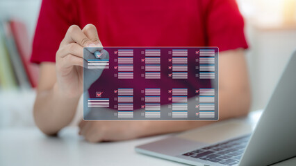 A person is holding a tablet with a screen displaying a grid of boxes