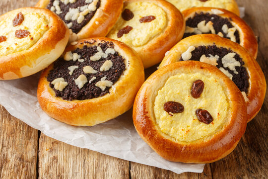 Sweet yeast buns Czech kolache made with cottage cheese or poppy seeds closeup on the wooden table. Horizontal